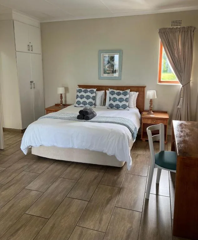 Bright bedroom with wooden bed frame and patterned cushions