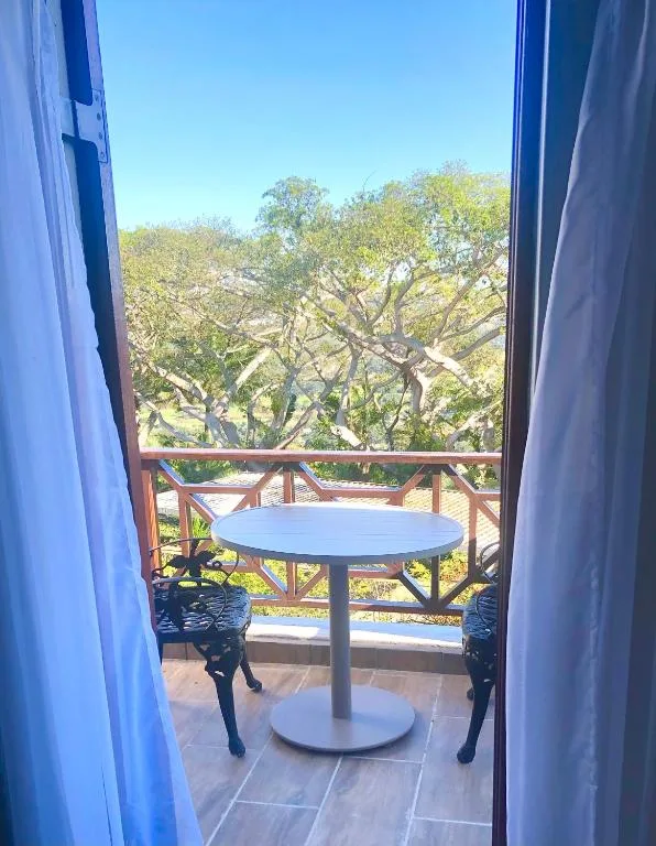 Outdoor balcony with table and chairs overlooking native trees