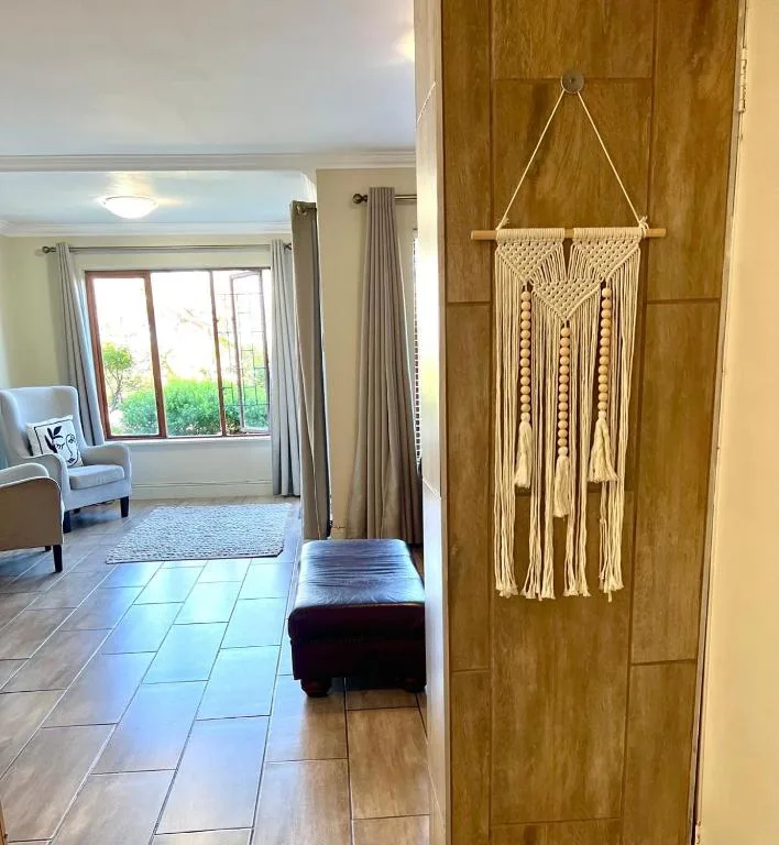 Macramé wall hanging and wooden door in modern accommodation hallway