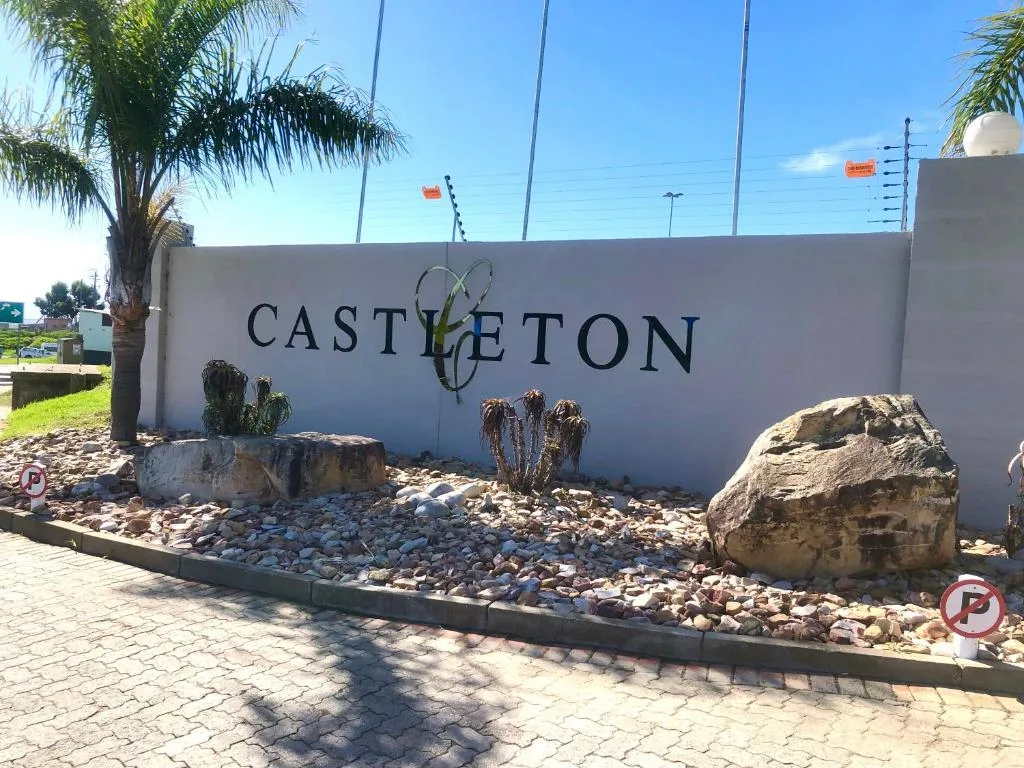 Castleton property entrance sign with landscaping and palm tree