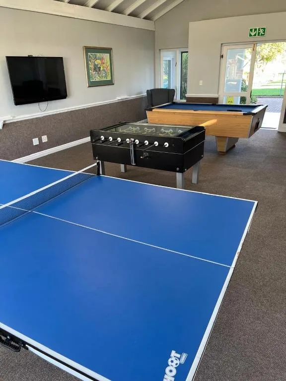 Game room with ping pong table, pool table, foosball table, and wall-mounted TV
