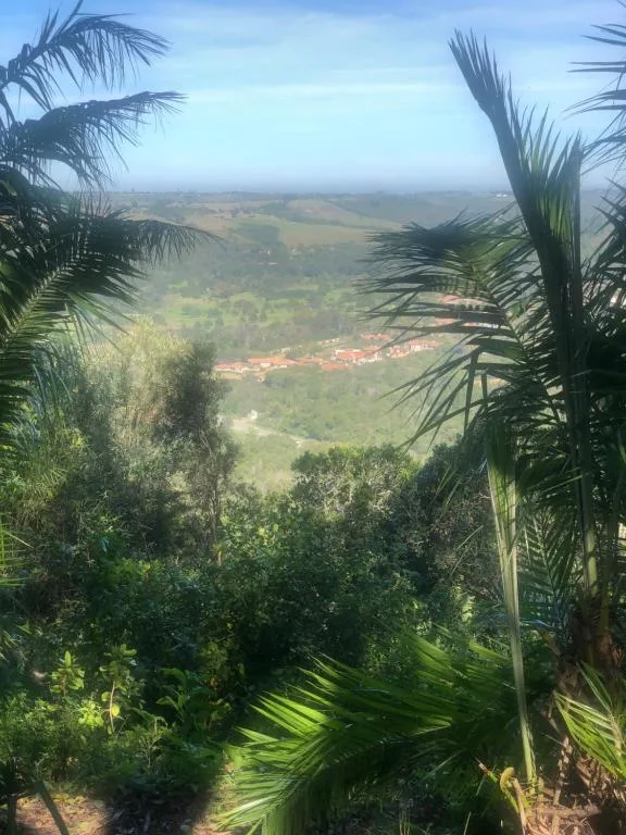 Expansive valley landscape with green fields and distant coastal settlement