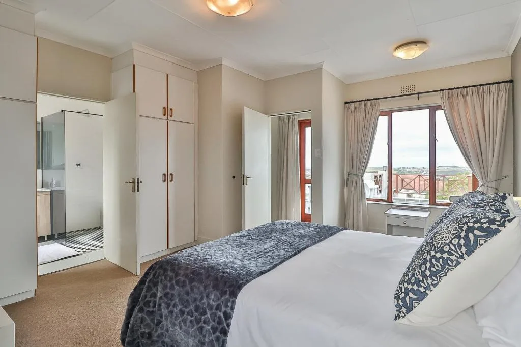 Spacious master bedroom with double bed and ensuite bathroom with scenic views
