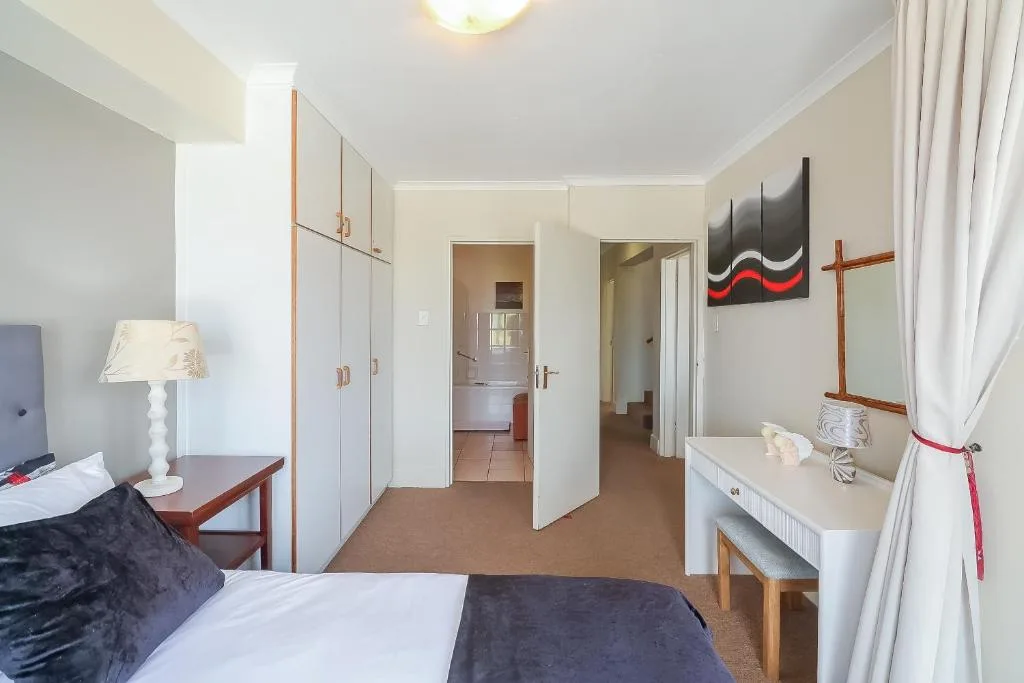 Spacious bedroom with double bed, wardrobe, desk, and ensuite bathroom access
