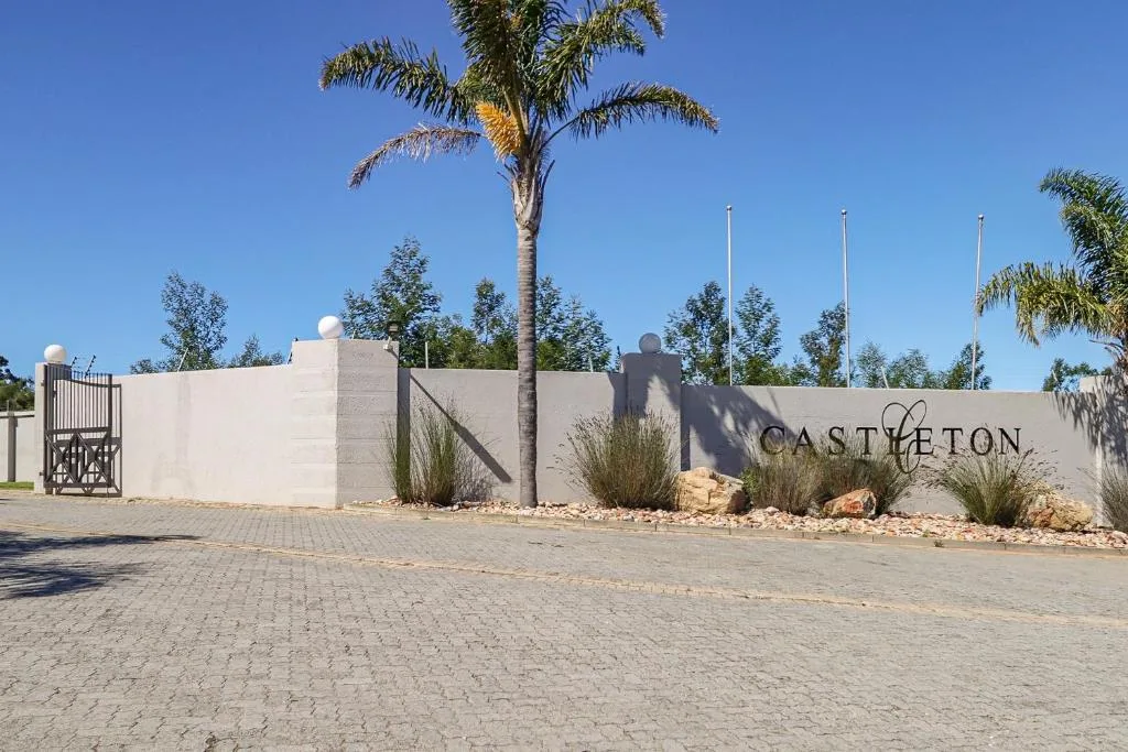 Modern white property entrance with Castleton signage and palm trees