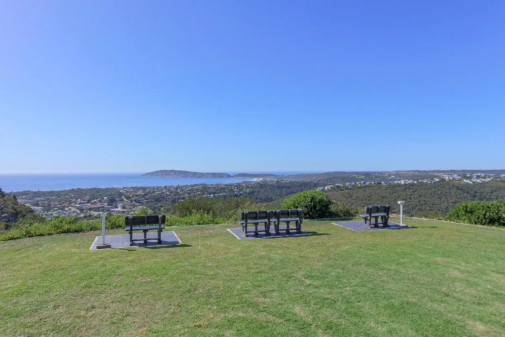 Scenic coastal vista with lagoon, headland, and seaside town nestled among green hills