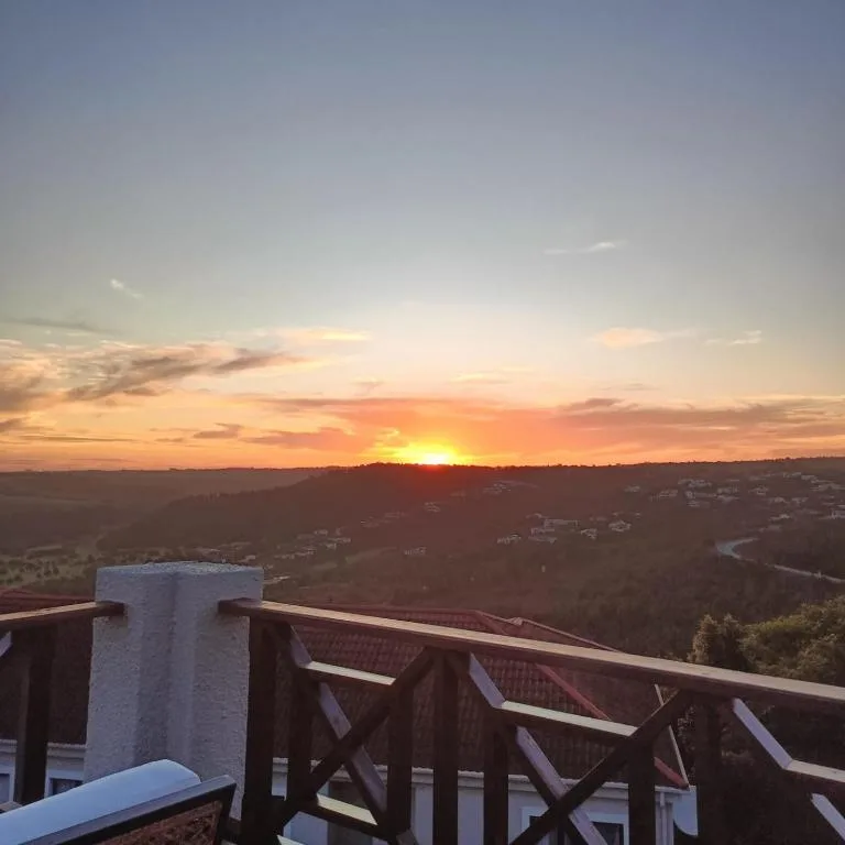 Stunning sunset over forested valley with distant houses and river bend