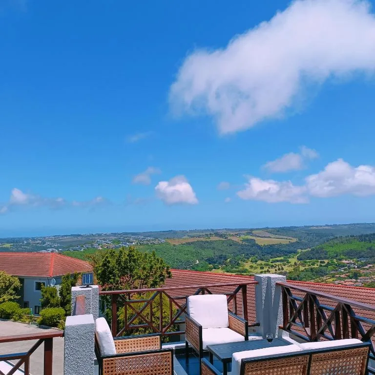 Expansive coastal landscape with rolling green hills and distant ocean horizon