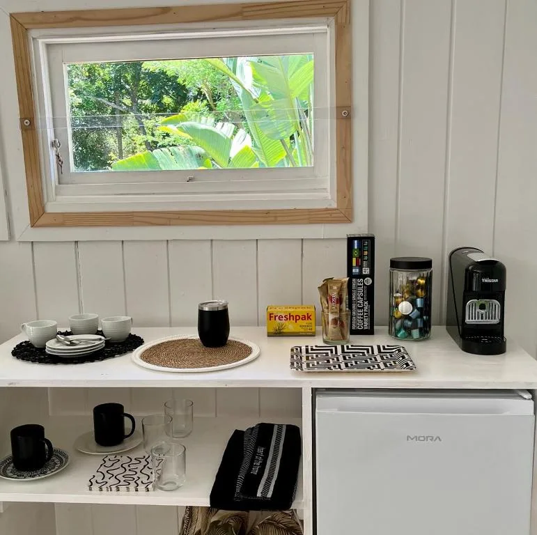 Kitchen shelf with coffee maker, mugs, and amenities display