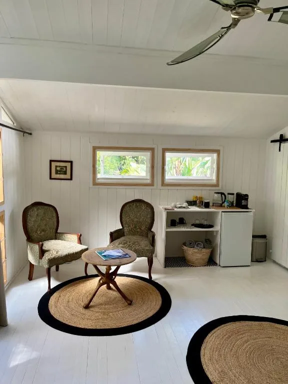 Bright cottage lounge with two armchairs, round table, and natural light