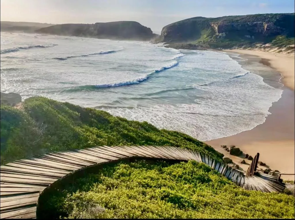 Scenic beach cove with towering cliffs and crashing ocean waves below