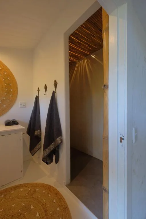 Modern bathroom with towel rails, decorative wall art, and wooden ceiling detail