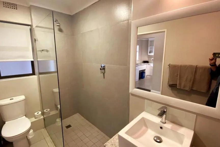 Modern bathroom with walk-in shower, vanity sink, and toilet
