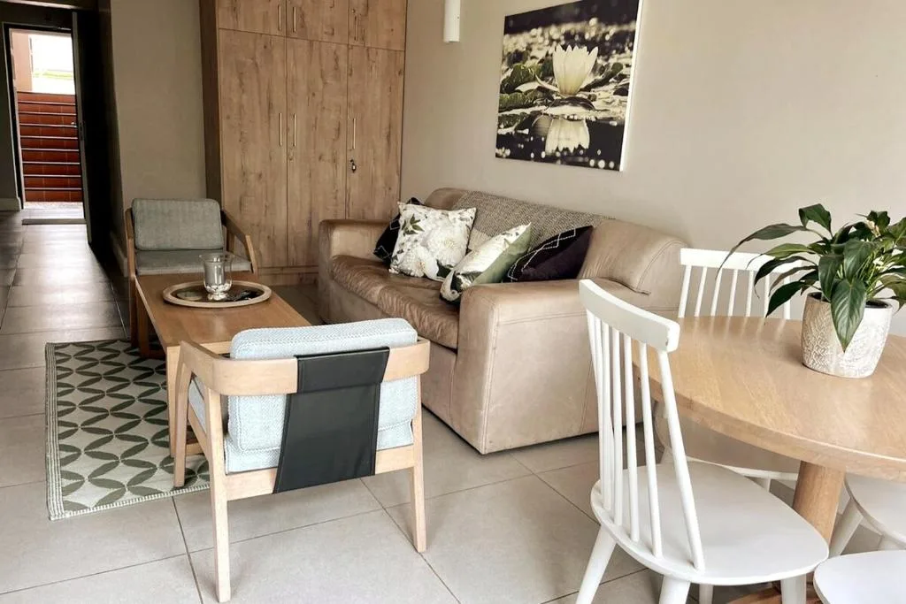 Comfortable beige sofa with decorative pillows in open-plan living area