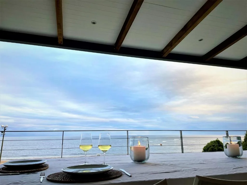 Oceanview deck with wine glasses and candles at sunset