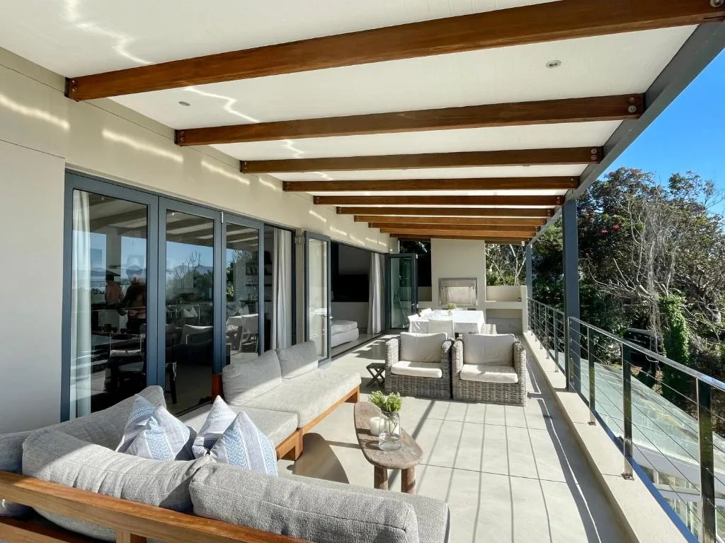 Spacious covered deck with seating areas and garden views