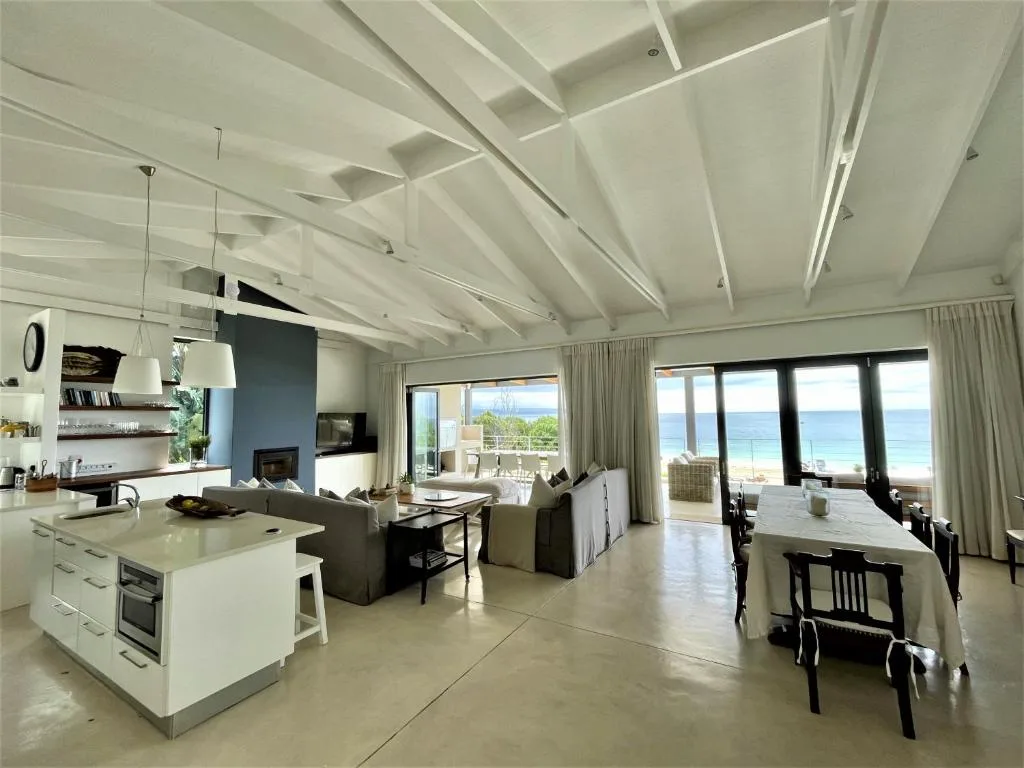 Modern open-plan living room with ocean views through glass doors