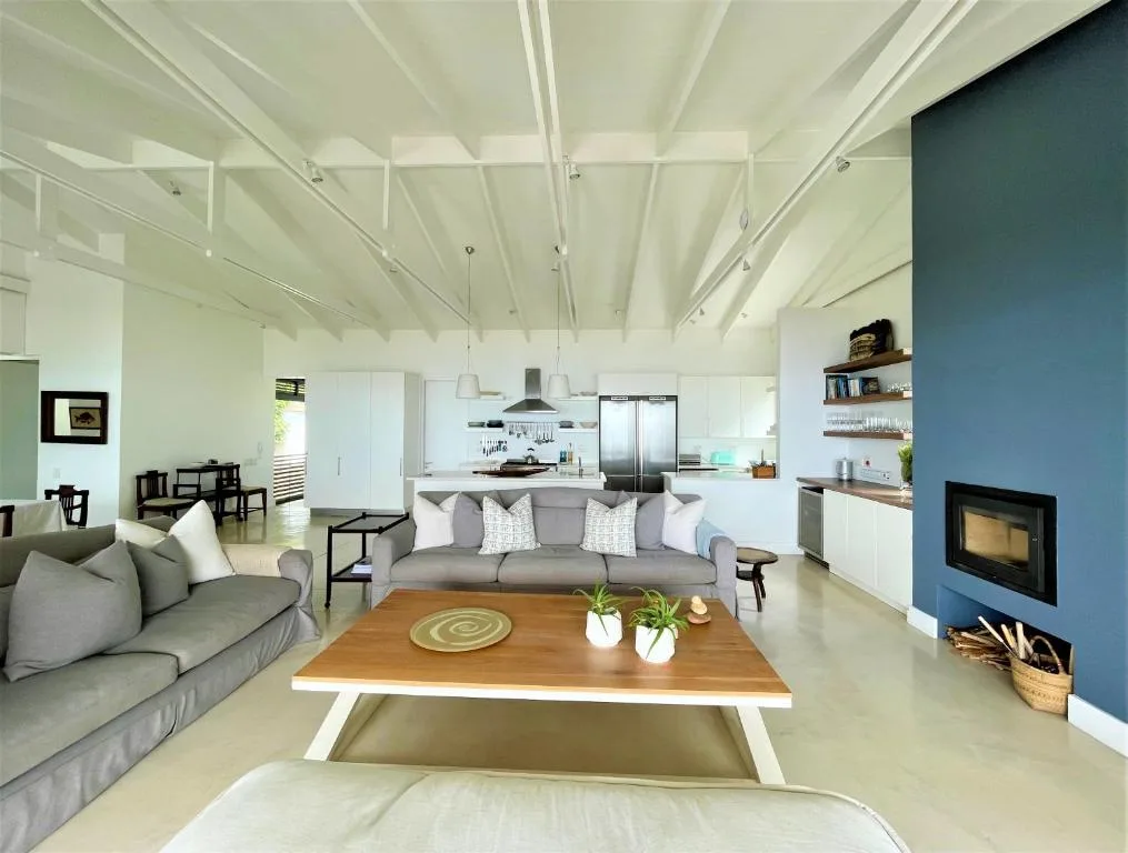 Modern open-plan lounge with grey sofas and wood coffee table, fireplace