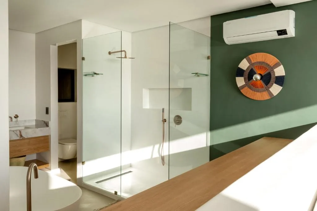 Modern bathroom with walk-in shower, green accent wall, and decorative art