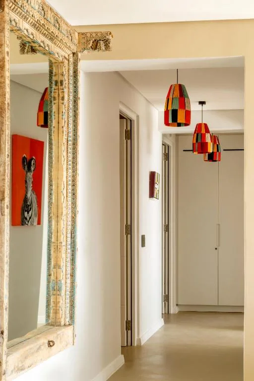 Modern hallway with colorful pendant lights and decorative mirror frame
