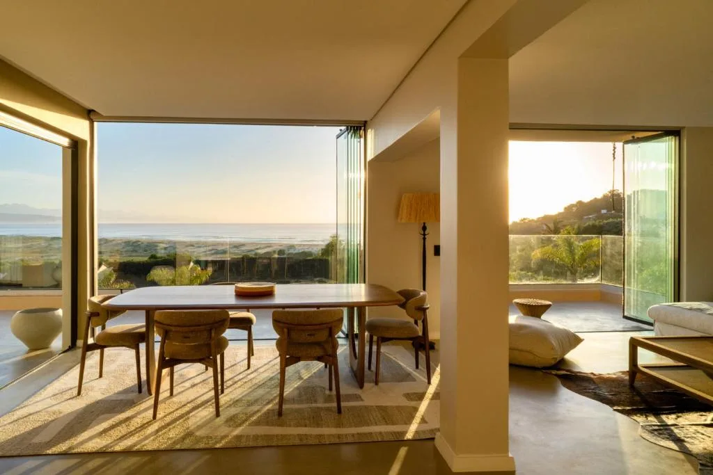 Modern dining area with ocean and lagoon views through floor-to-ceiling windows