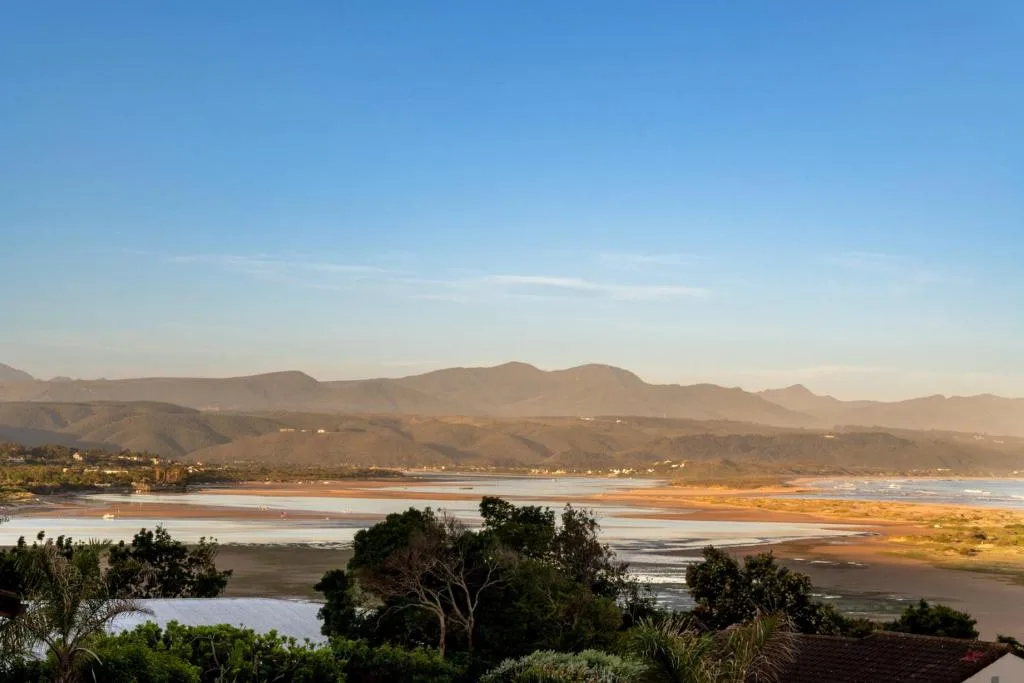 Scenic coastal view of lagoon and mountains under clear blue sky