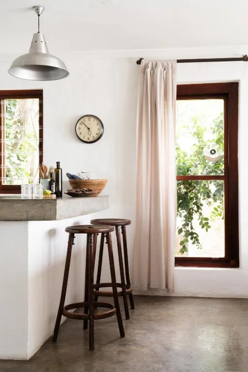 Modern kitchen with concrete countertop, industrial pendant light, bar seating