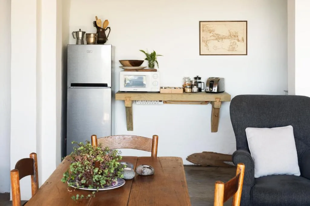 Modern kitchen area with stainless steel refrigerator and wooden shelving