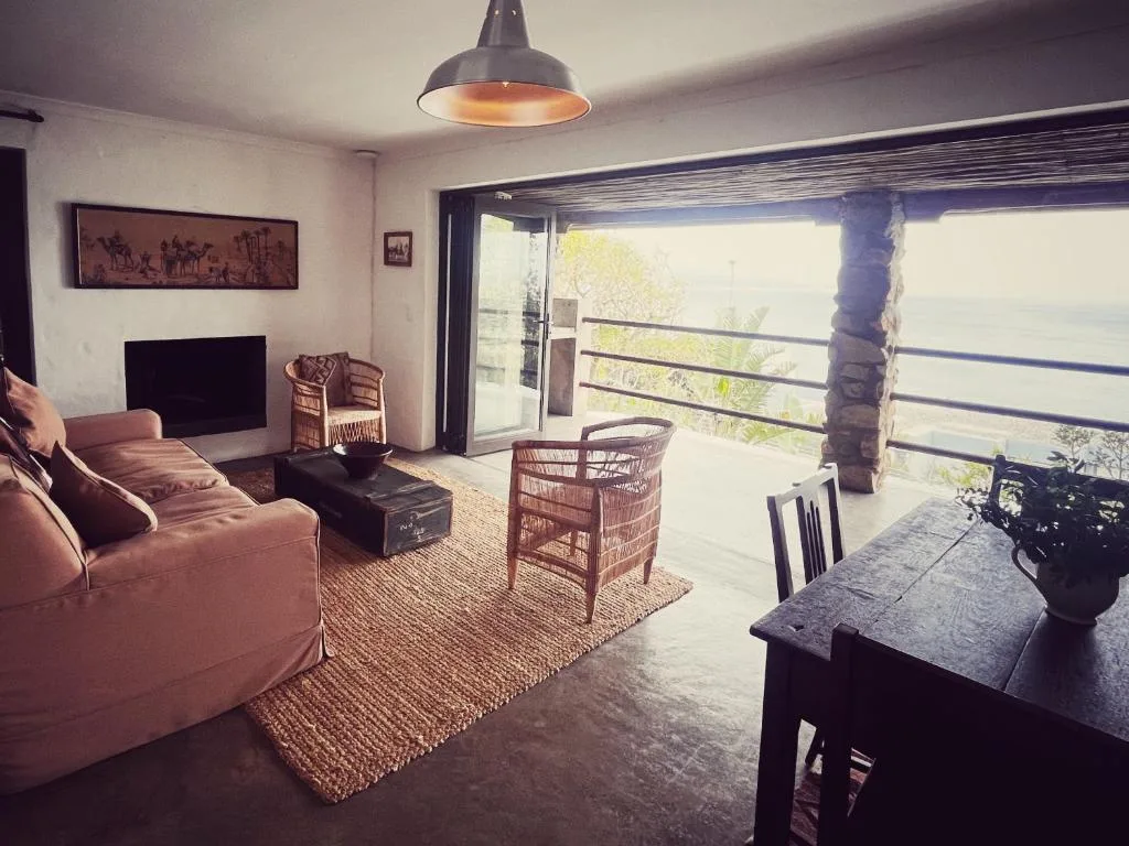 Modern lounge with pink sofa, pendant light, and sliding glass doors overlooking garden