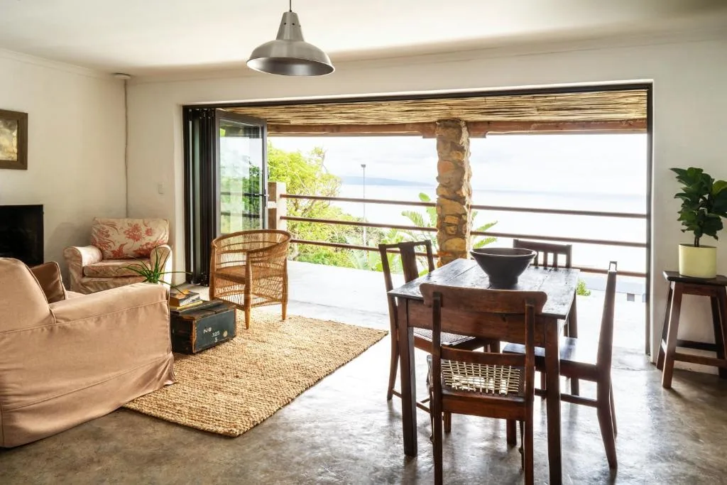 Open-plan living and dining area with ocean views through large glass doors
