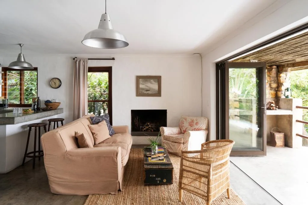 Open-plan lounge with beige sofa, fireplace, and garden views through sliding doors