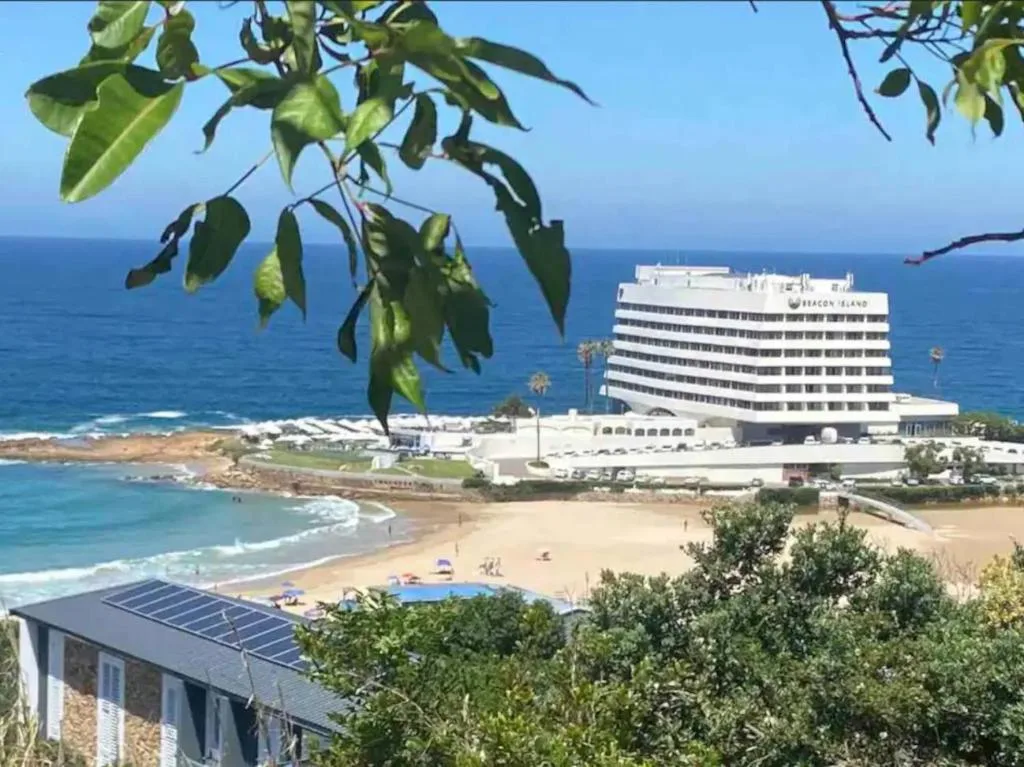 Scenic ocean and beach view with coastal town and hotel building