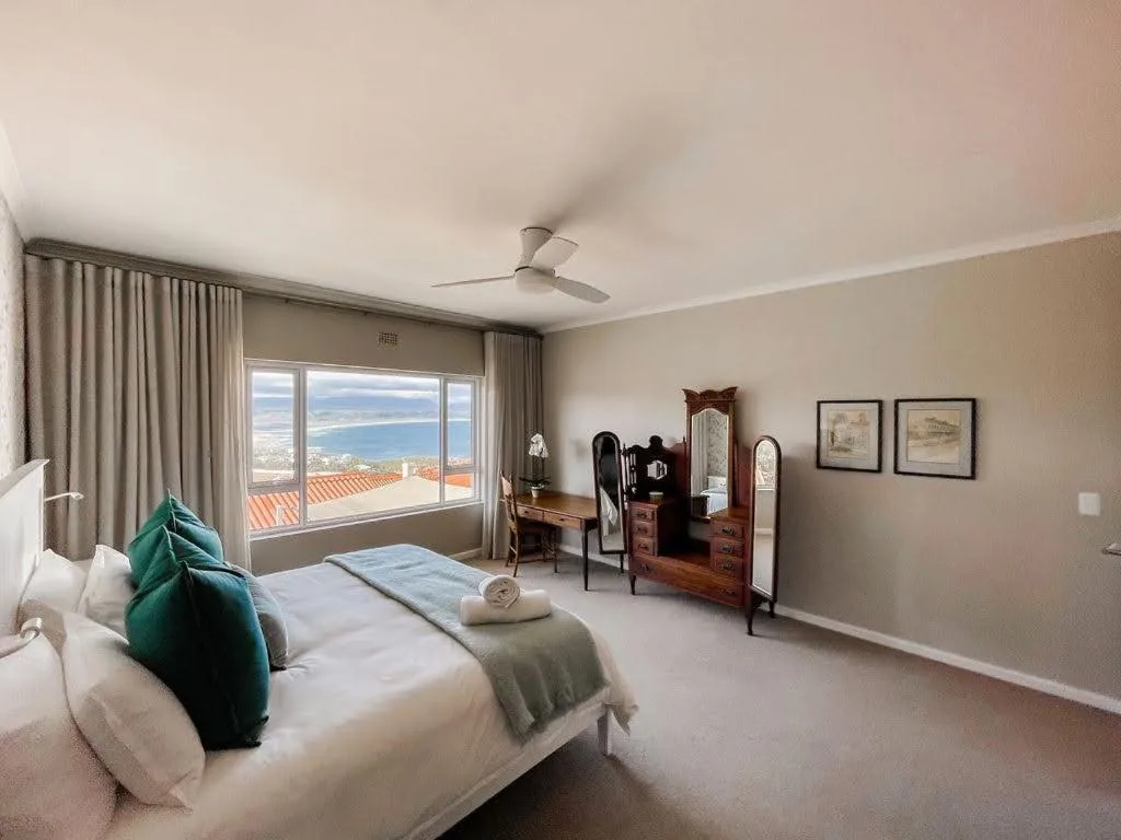 Spacious bedroom with ocean view through large windows and elegant furnishings