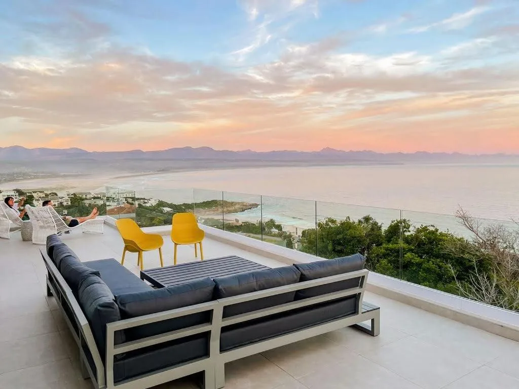Elevated terrace with lounge seating overlooking lagoon and mountains