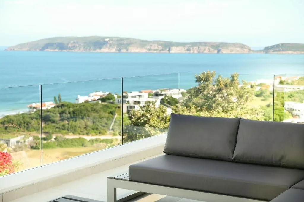 Modern patio with gray cushioned seating overlooking coastal bay views