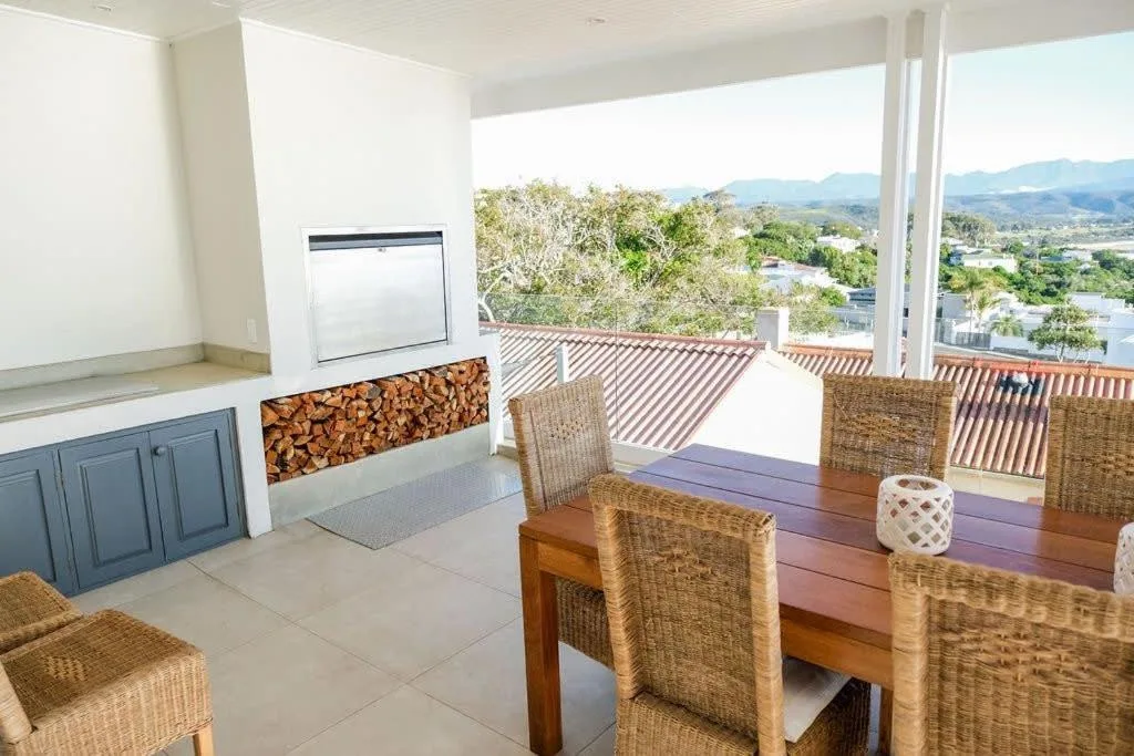 Covered patio with dining table, wicker chairs, and mountain views
