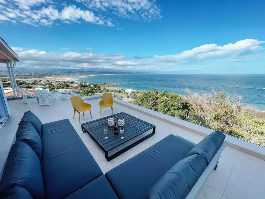Modern patio with ocean views, blue seating, and coastal landscape horizon
