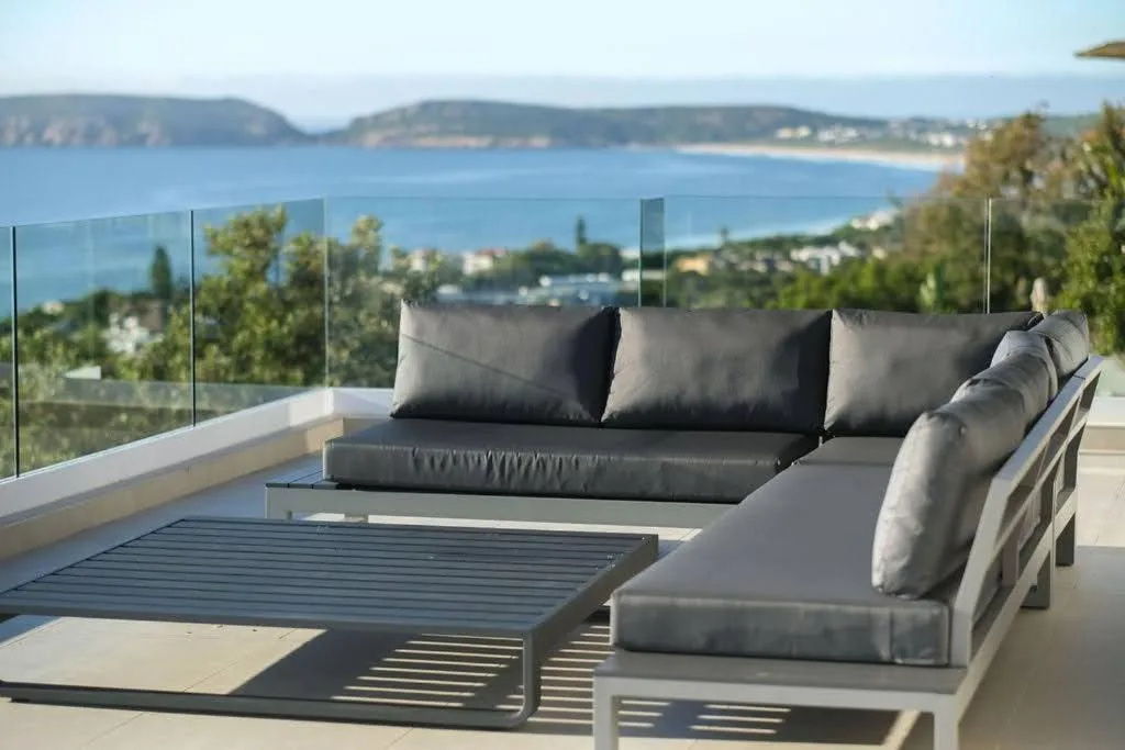 Modern outdoor seating area overlooking coastal bay and mountains