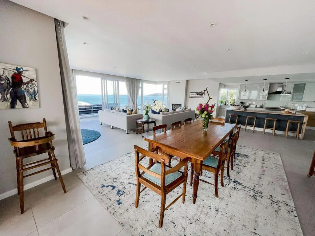 Open-plan dining area with wooden table overlooking ocean view