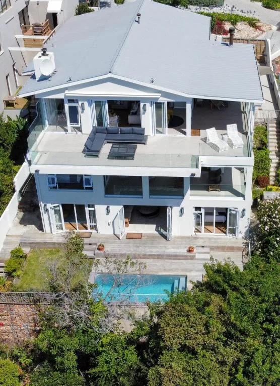 Modern villa with pool viewed from above, grey roof and white walls