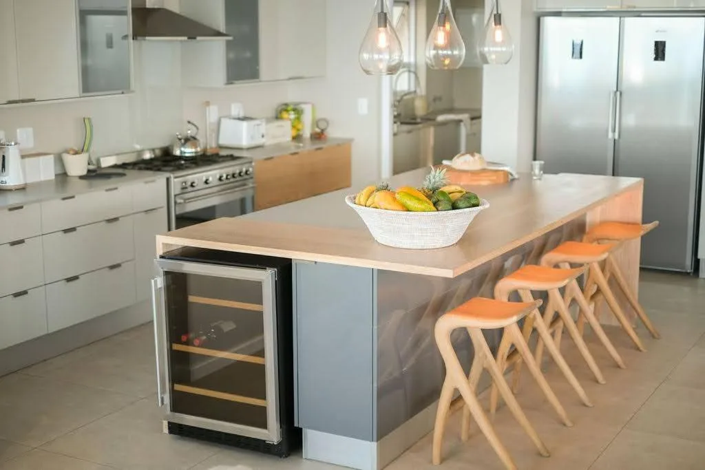 Modern kitchen with island, stainless steel appliances, and wooden bar seating