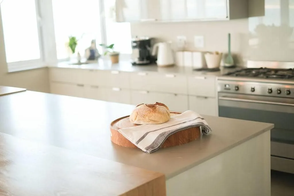 Modern kitchen with island counter, stainless steel range, and bright windows