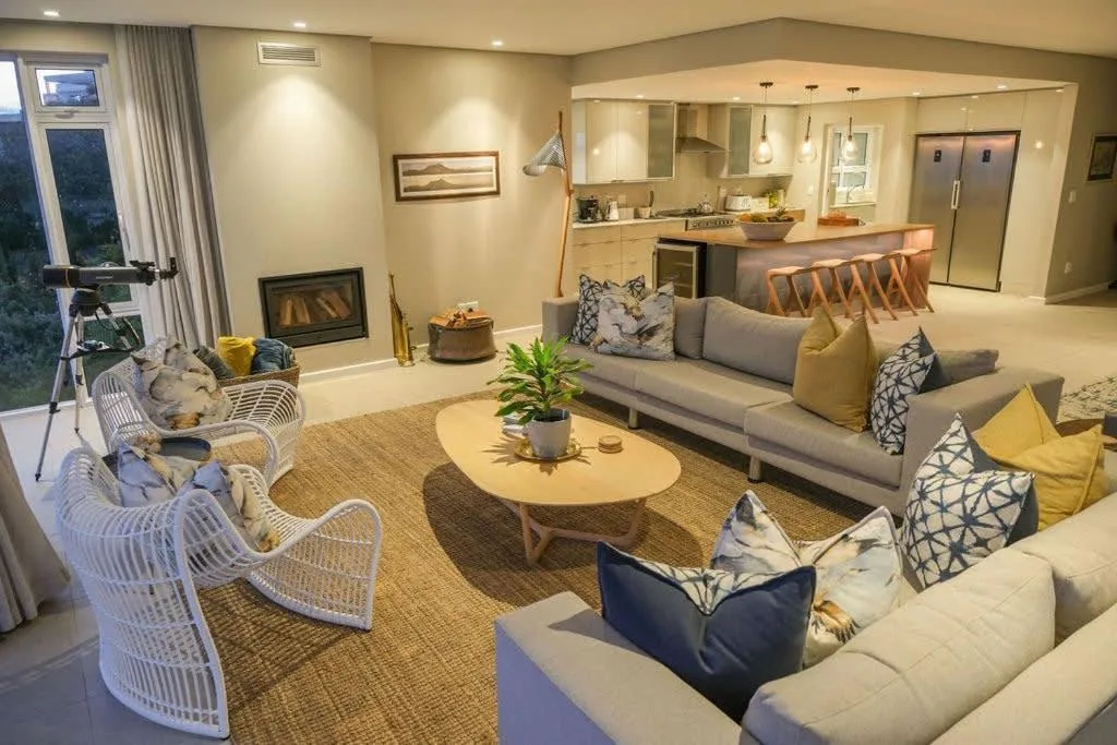 Modern lounge with gray sofas, fireplace, and open-plan kitchen view