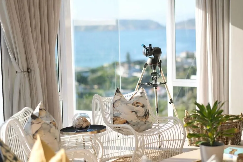 Scenic ocean and coastline vista through large windows with telescope