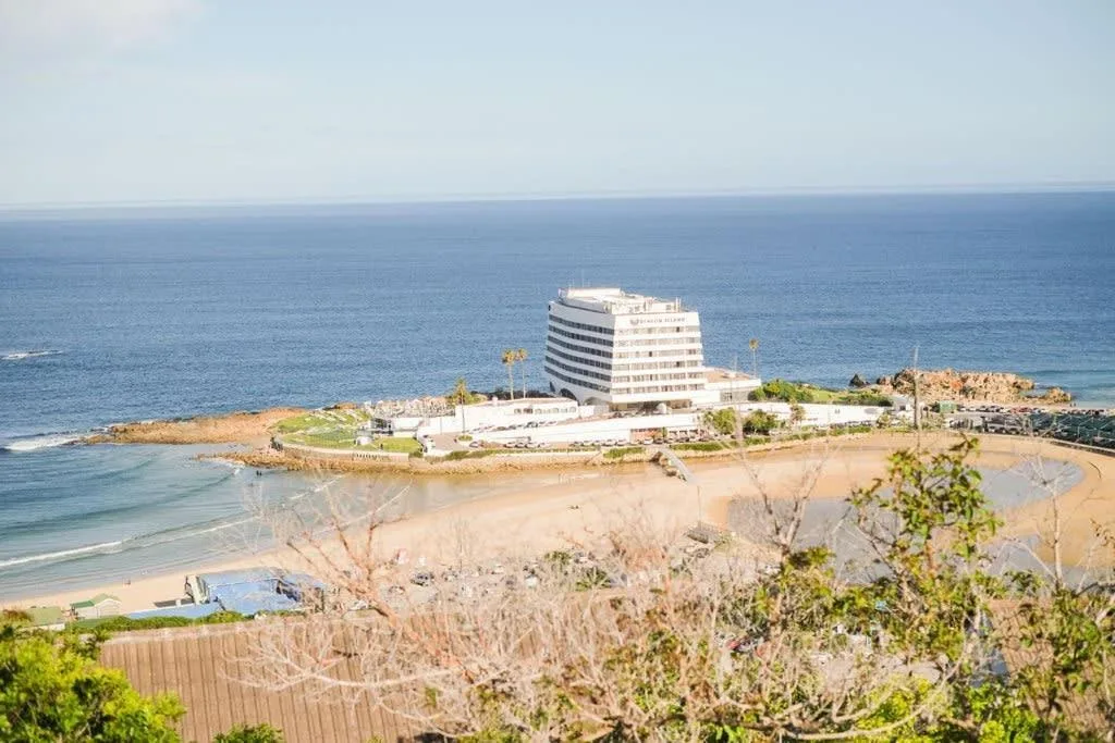 Coastal beachfront property with ocean and sandy beach panorama