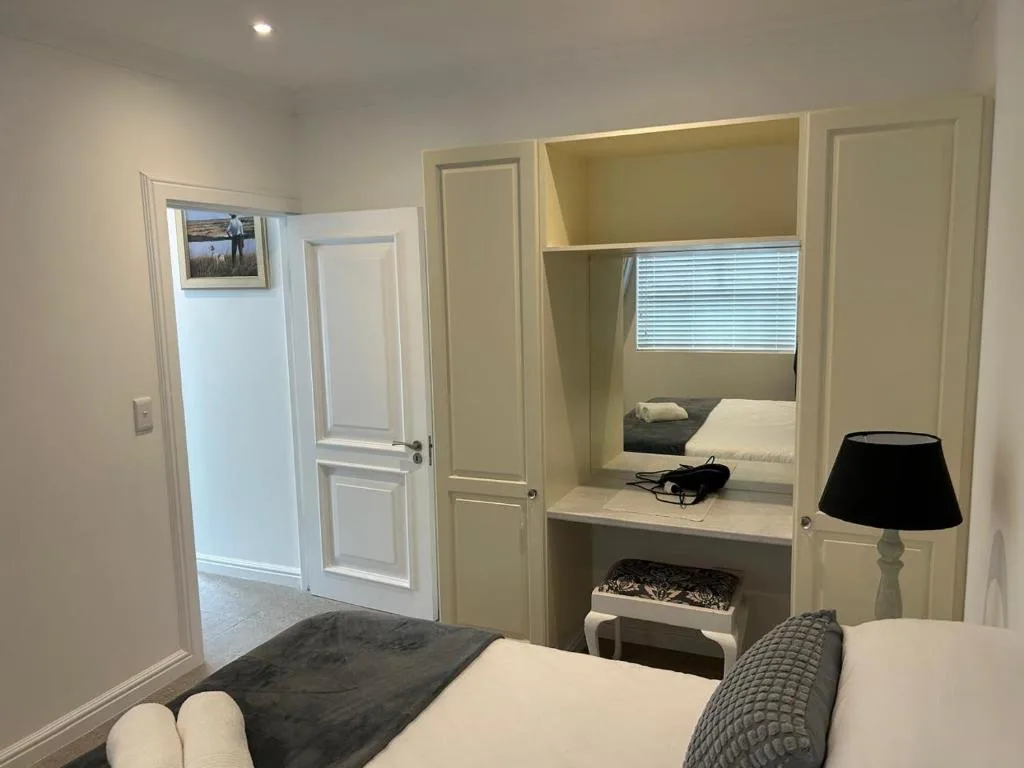 Modern bedroom with built-in vanity, single bed, and contemporary furnishings throughout