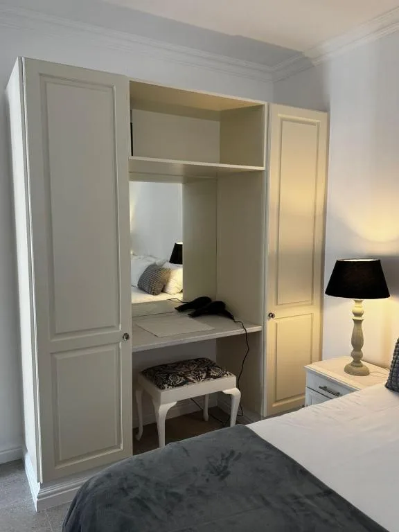 Built-in bed alcove with white cabinetry and modern bedding setup