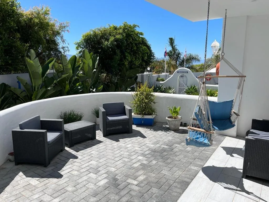 Spacious rooftop patio with seating, potted plants, and hanging swing chair