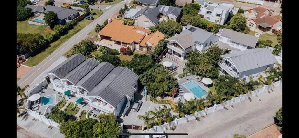 Aerial view of beachfront property with pool and landscaped gardens