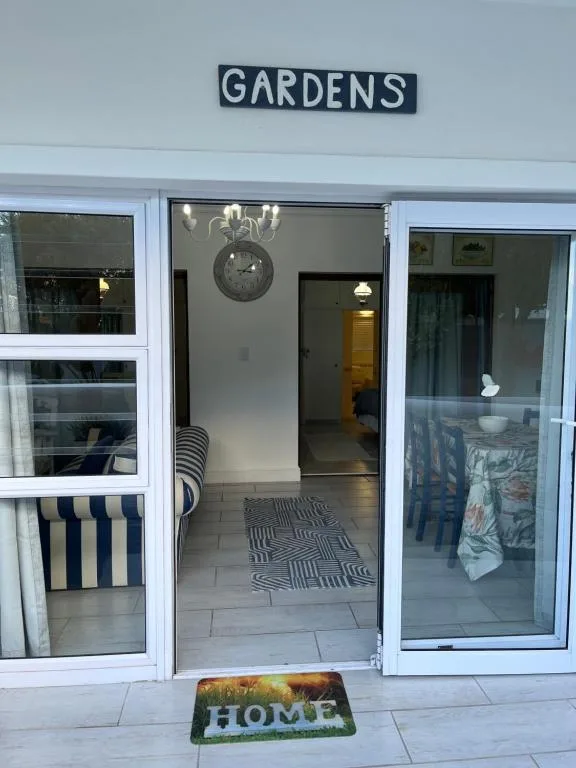 Modern apartment entrance with gardens sign and home welcome mat
